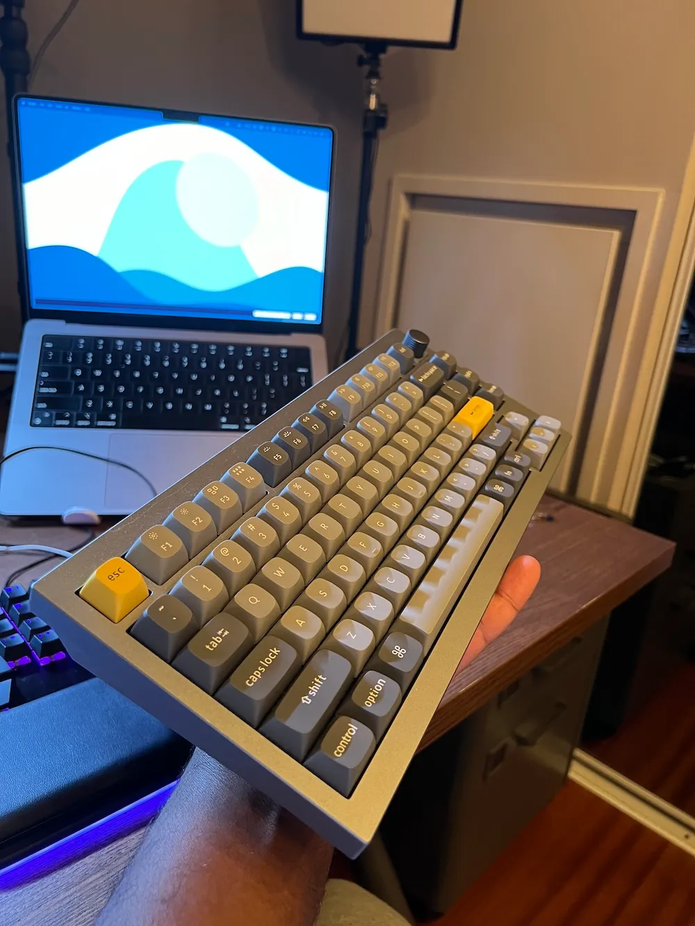 Photo of the Keychron Q1 side view, in my hand, facing my MacBook Pro